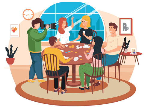 Friends playing cards sitting at a table. Photographer takes photos of young people having good time together at home or cafe. Happy people are resting, drinking coffee and playing a board game