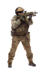 Full length portrait of soldier in combat ammunition in hard hat and glasses with a weapon equipped with collimator sight is aiming at the enemy ready to shoot to kill isolated on white background