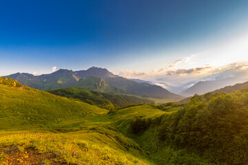 Beautiful mountain landscape at Caucasus mountains with clouds and blue sky