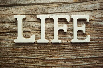 Life alphabet letter on wooden background
