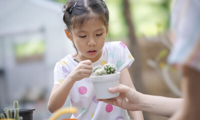 Mother and daughter working in cactus garden.