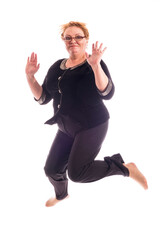 Middle aged woman in black jacket and trousers jumping