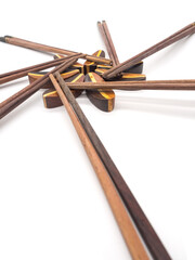 Isolated of Wooden chopsticks on chopstick rest arrange in flower shape