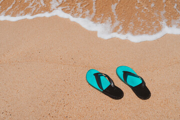 Fototapeta na wymiar Slippers on the sand at the sea with space , summer holiday and vacation.