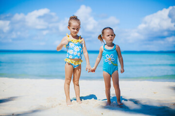 Naklejka premium Adorable little girls have a lot of fun on the beach
