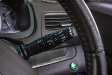 Fototapeta na wymiar Switch off lights in a car. close-up Car integrated turning indicator with headlight switch toggle.