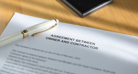 A agreement between owner and contractor on the desk.
