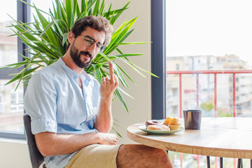 bearded man feeling angry, annoyed, rebellious and aggressive, flipping the middle finger, fighting...