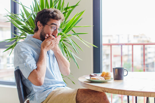bearded man covering mouth with hands with a shocked, surprised expression, keeping a secret or saying oops