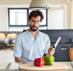 bearded man feeling disgusted and irritated, sticking tongue out, disliking something nasty and...