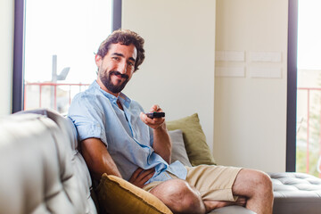 bearded man smiling happily with a hand on hip and confident, positive, proud and friendly attitude