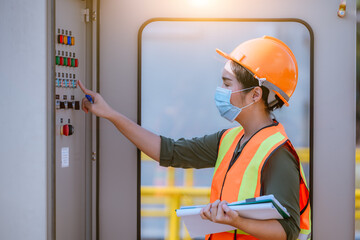 Worker checking and inspecting at MDB panel ,working with electric switchboard to check range of voltage in Main Distribution water to support station, wearing mask to protect virus and pollution.