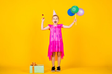 funny girl have fun on holiday. Happy child plays with balloons. happy kid with present box. happy childrens day. childhood happiness. Concept of freedom and imagination