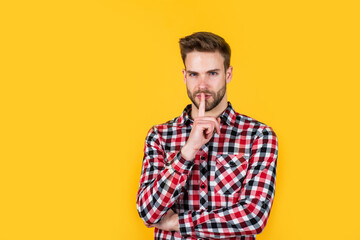 keep the secret. handsome casual man standing with beard and bristle. cheerful and stylish. handsome man on red background. portrait of sexy european businessman. confident and calm. copy space