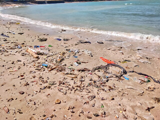 Plastic waste in the sand left on the beach