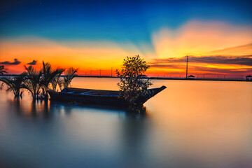 A scenic beauty of traditional fishing boat with sunset at Teluk Sengat,Johore, Malaysia with Soft focus due to long exposure.