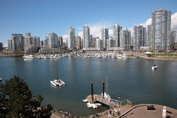 Fototapeta na wymiar View of Vancouver False Creek waterfront skyline with sailboats and ferryboats during springtime Seen from Cambie Bridge in the downtown of Vancouver, British Columbia, Canada.
