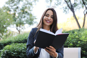 Fototapeta premium Young business woman smiling outdoor, wearing a suit.