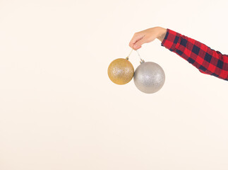Two large silver and golden New Year balls for the Christmas tree in hand on a white background: space for text