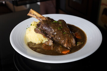 Lamb shank with potato mash, honey glazed carrots and mint gravy