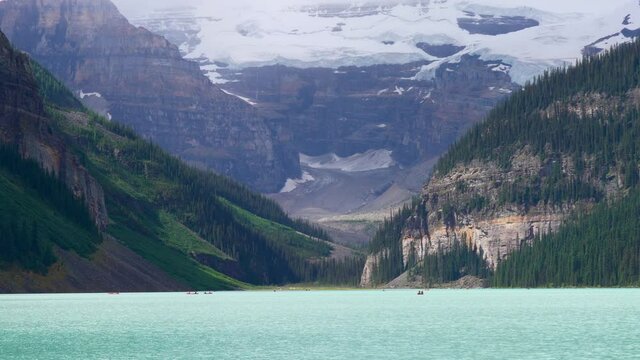 Canoeing on Lake Louise in summer day. Tourists enjoy leisure water activities on the turquoise color lake in Banff National Park, Alberta, Canada.