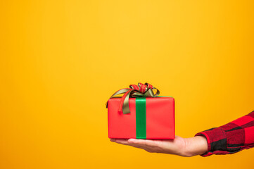 Palm up male hands holding the box celebrate with his birthday on yellow background. Merry christmas and Happy new year 2021 male hands holding the present gift box with copy space.