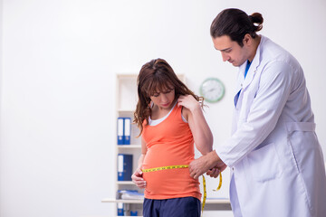 Fototapeta premium Pregnant woman visiting male doctor gynecologist