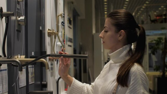 Professional designer chooses black shower for bathroom holding in hand and standing in local hardware store. Concept apartment style