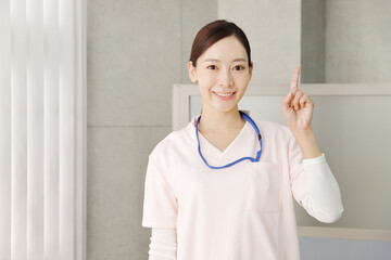 指差しポーズで笑顔の女性看護師
