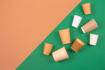 Set of eco-friendly takeaway beverages cups - kraft paper coffee cups on green and brown background...