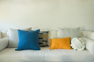 Beautiful modern living room interior with white sofa, colorful pillows, wood table and decorated...