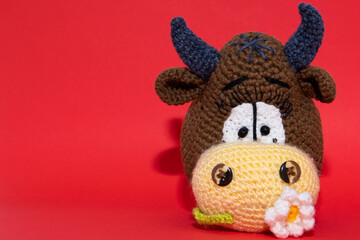 big bull's head on the red background with flower on it's mouth