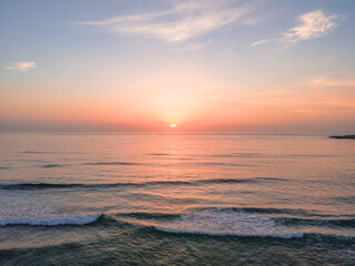 Soft haze and pastel coloured sunrise seascape