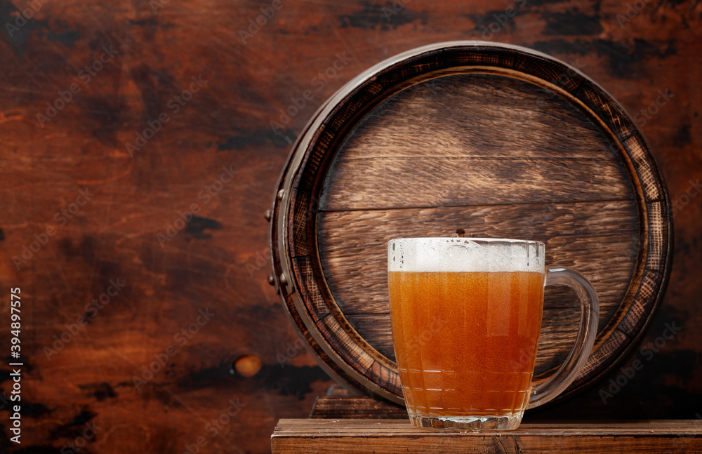 Wall mural Mug of light lager beer and old wooden barrel