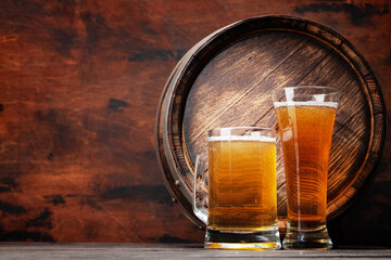 Mug and glass of light lager beer and wooden barrel