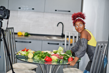 African american woman filming her blog broadcast about healthy food at home kitchen.