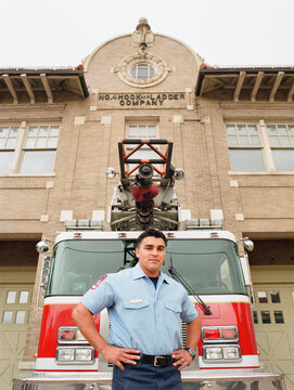 Fireman posing for the camera by fire engine