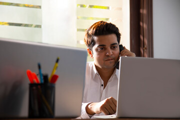 AN OFFICE EXECUTIVE TALKING TO CLIENT OVER TELEPHONE	