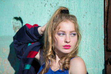 Portrait of a funny brunette girl with bright makeup in a sports trowel. Girl in the style of the eighties.