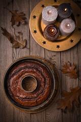 Vegan banana cake, background decorated with autumn and winter candles