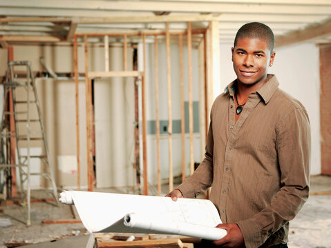Architect holding blueprints in construction site