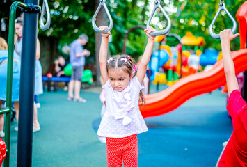Fototapeta na wymiar Cute little girl having fun on a playground outdoors in summer 
