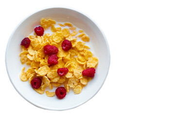 Cornflakes with raspberries on a white plate on a white background.