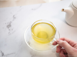 透明耐熱グラスに急須で注がれた緑茶・日本茶を家で飲む様子。