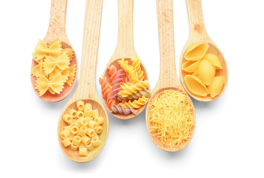 Spoons with different uncooked pasta on white background - Powered by Adobe