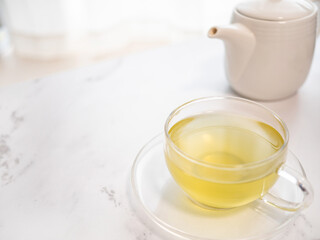 透明耐熱グラスに急須で注がれた緑茶・日本茶を家で飲む様子。