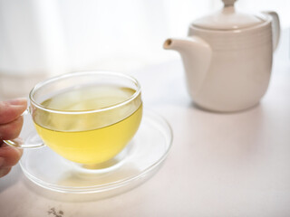 透明耐熱グラスに急須で注がれた緑茶・日本茶を家で飲む様子。