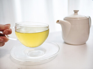 透明耐熱グラスに急須で注がれた緑茶・日本茶を家で飲む様子。