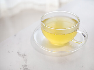 透明耐熱グラスに急須で注がれた緑茶・日本茶を家で飲む様子。