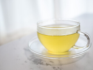透明耐熱グラスに急須で注がれた緑茶・日本茶を家で飲む様子。